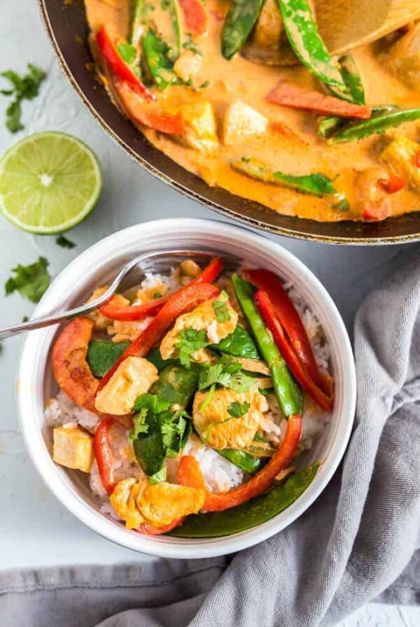 A bowl and skillet filled with coconut curry chicken.