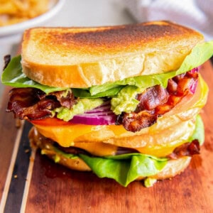 A BLT grilled cheese sandwich with lettuce, tomato, red onion, cheddar cheese, guacamole and chipotle mayo.