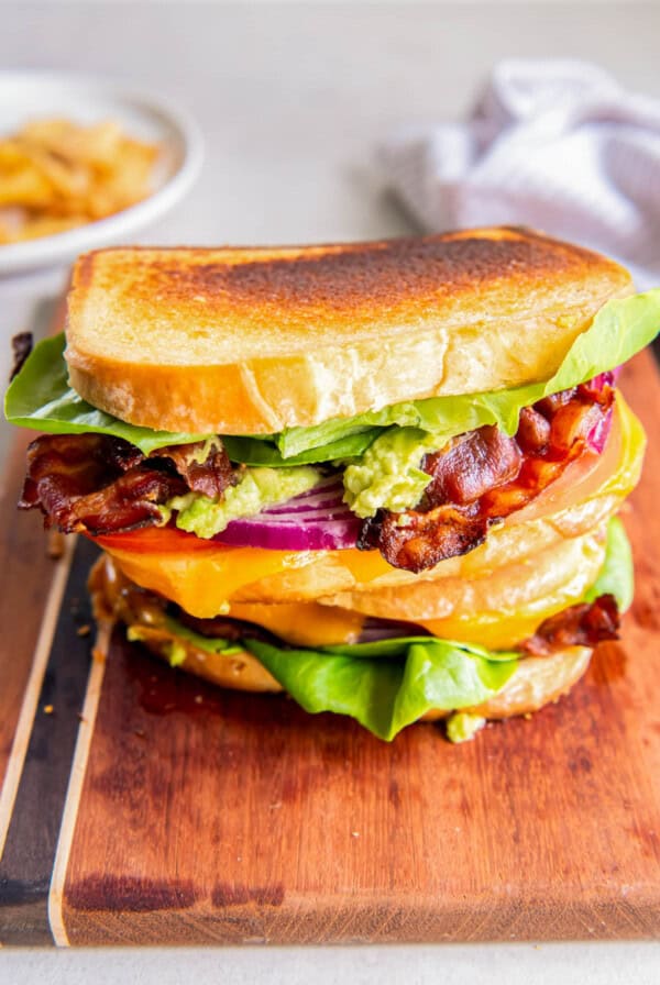 A BLT grilled cheese sandwich with lettuce, tomato, red onion, cheddar cheese, guacamole and chipotle mayo.