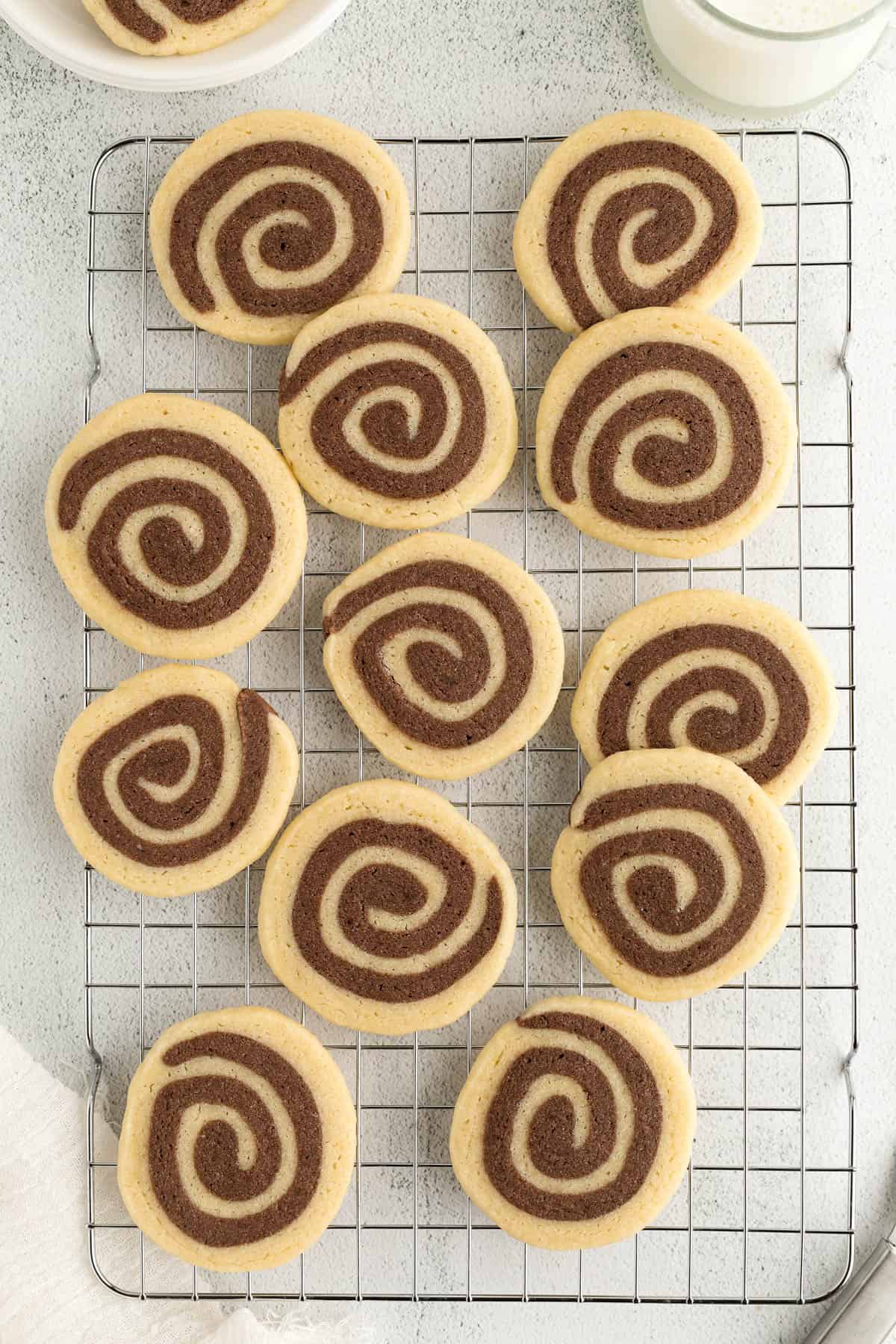 Baked pinwheel cookies on a baking rack after baking.