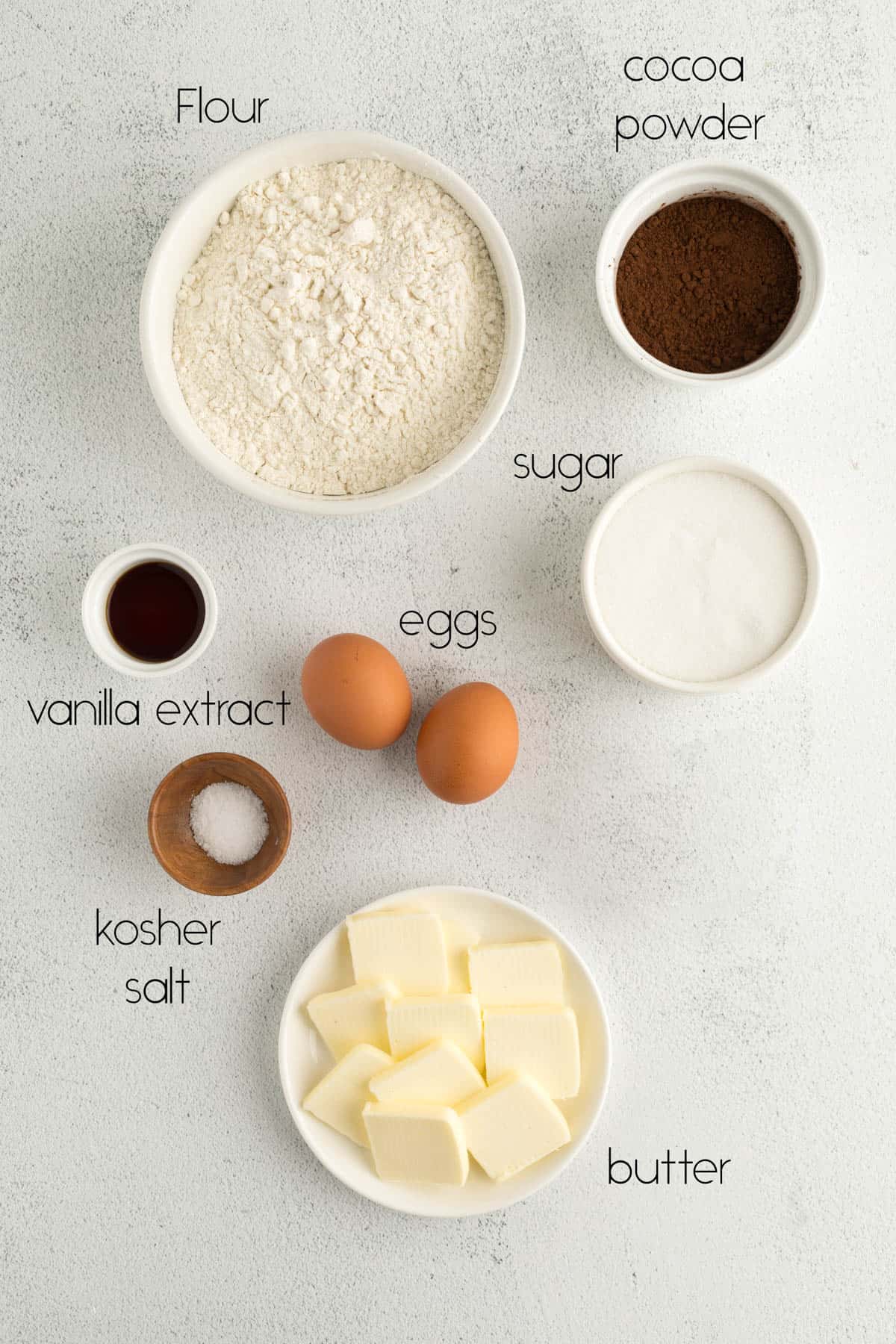 All of the ingredients needed for swirl cookies in bowls on a white countertop. 