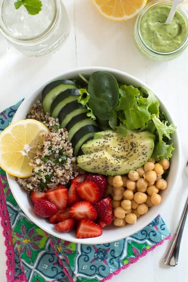 Nourish yourself with a berry green Buddha bowl with lemon avocado kale mint dressing!