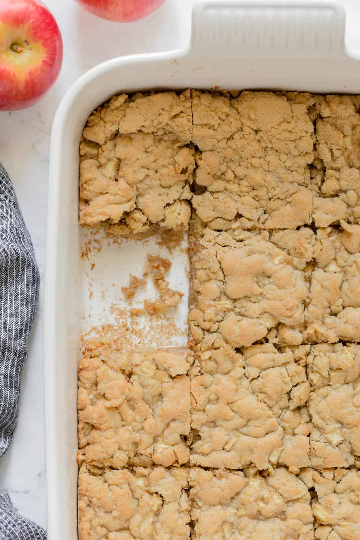 Baking dish with one slice of apple cake removed.