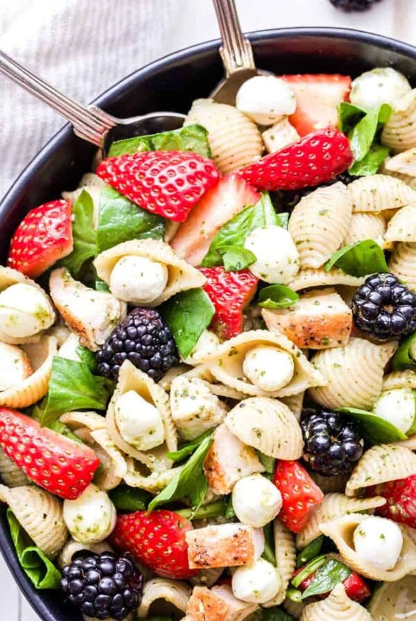 This Chicken and Berry Pesto Pasta Salad is a flavorful and easy to make main dish salad. All the flavors of caprese salad, but using berries instead of tomatoes! #pastasalad #pesto #strawberries #chicken