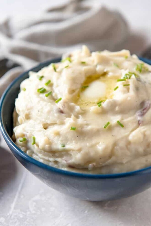 a bowl of mashed potatoes with a slice of melted butter on top