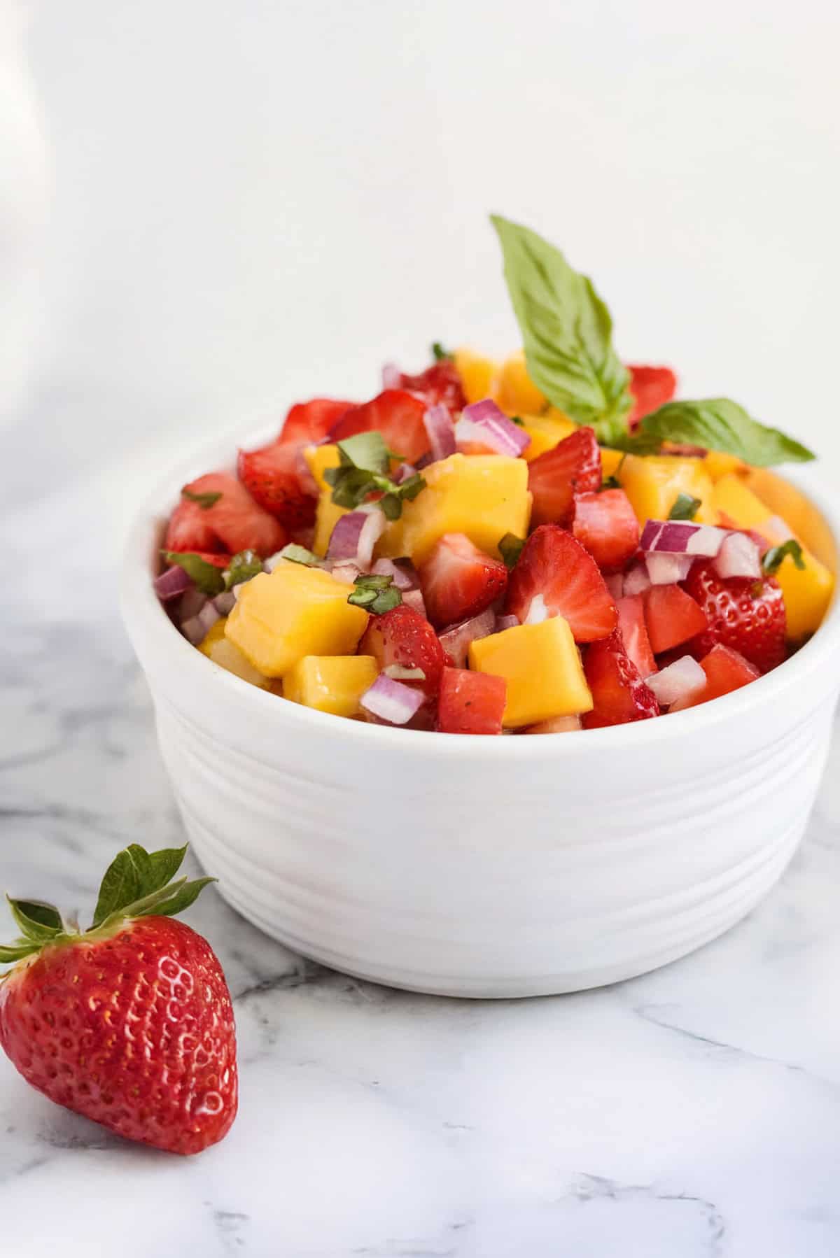 Chopped mango salsa in a white bowl.