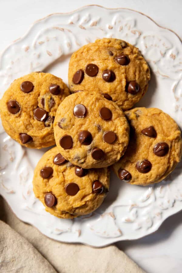 a plate with five soft pumpkin chocolate chip cookies