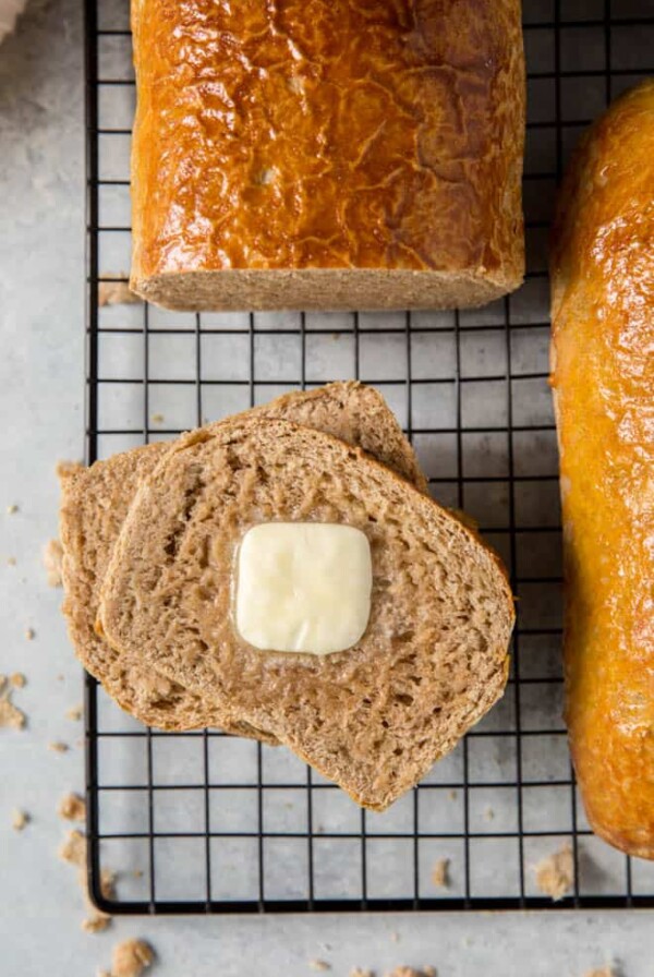 Two slices of wheat bread with a slice of butter on top