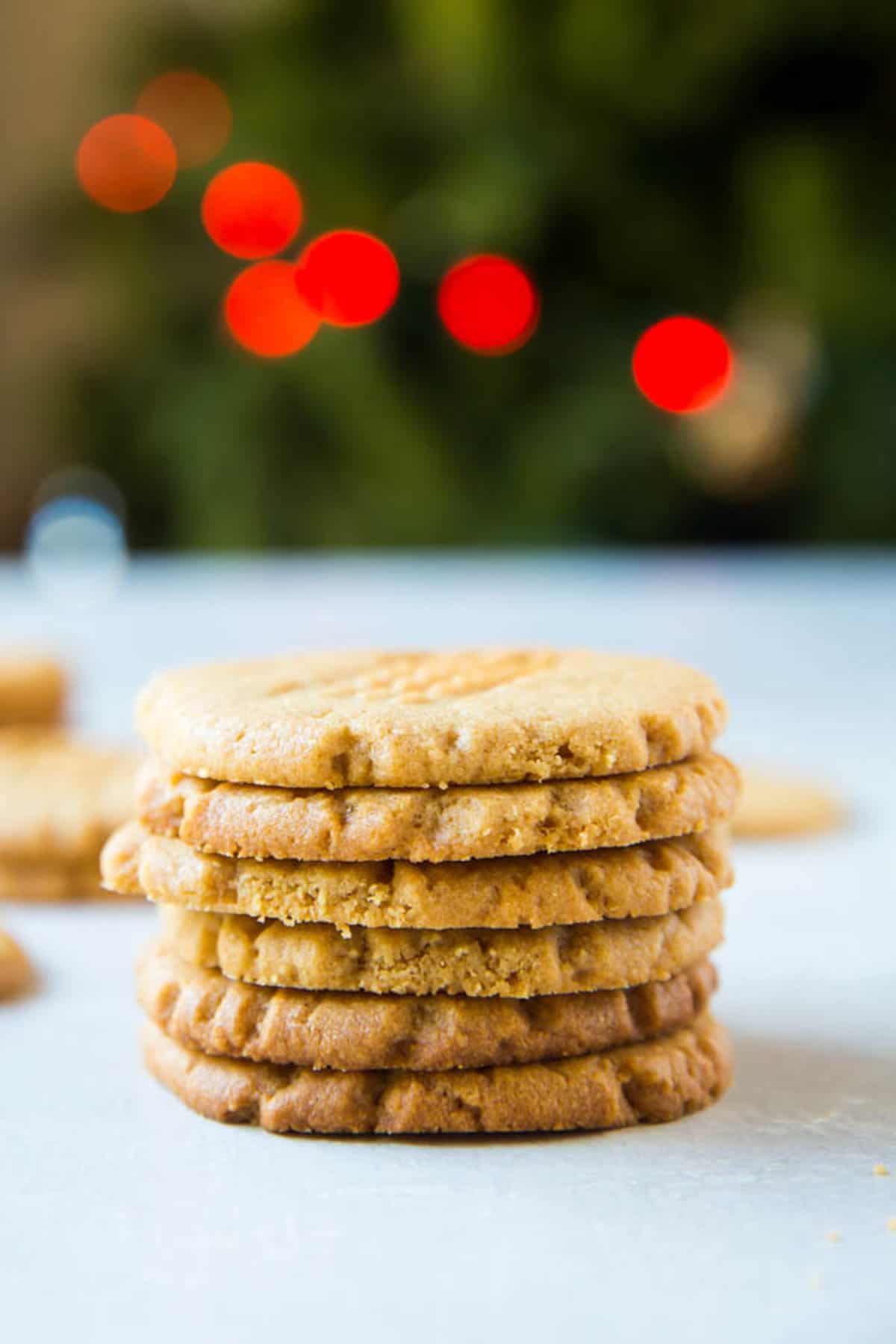 A stack of peanut butter cookies with a festive Christmas background.