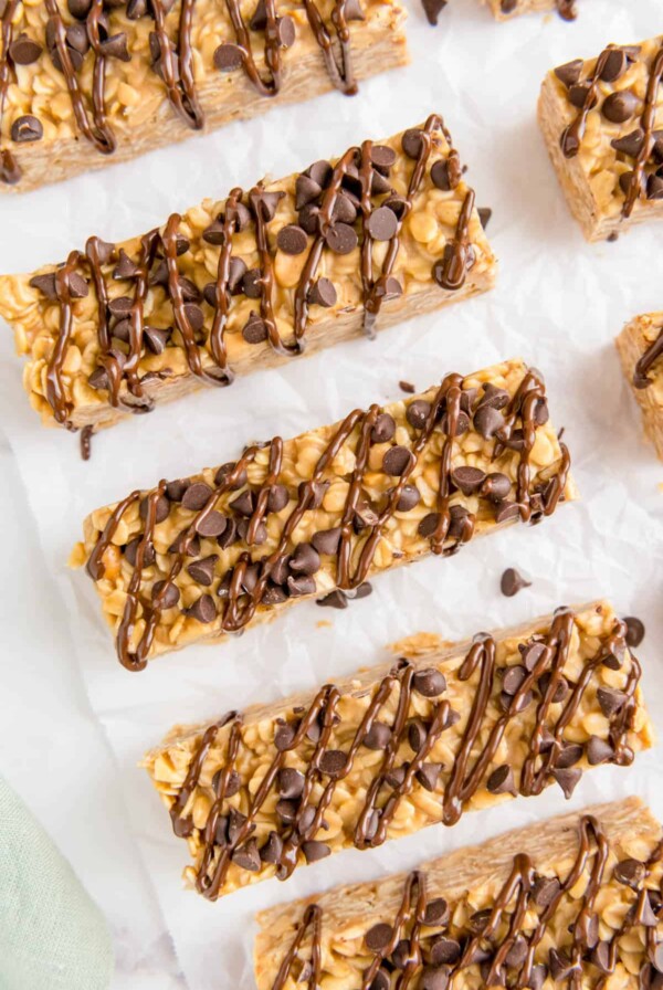 five chocolate chip peanut butter granola bars on a piece of white parchment paper