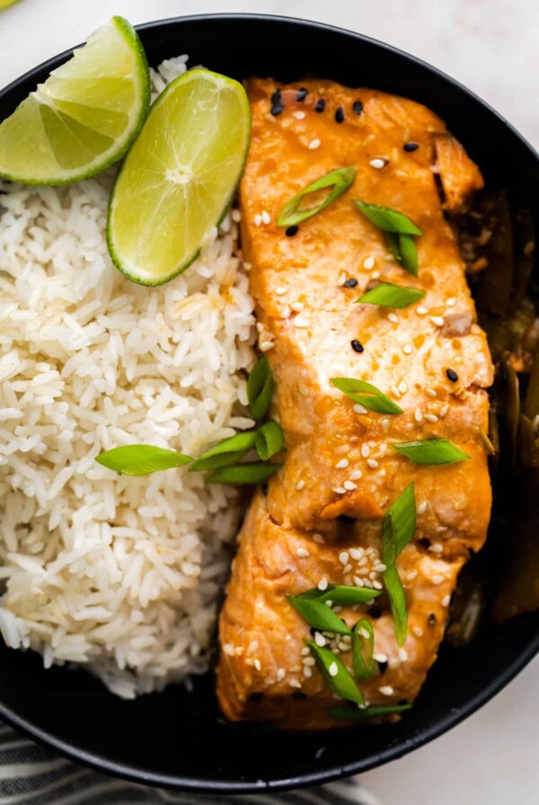 a slice of cooked sesame salmon on a plate with rice