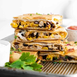 a stack of four pieces of sheet pan quesadillas sitting on a pan