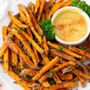 A plate of sweet potato fries with sauce