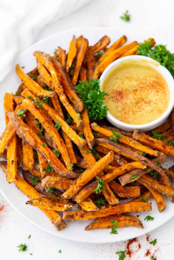 A plate of sweet potato fries with sauce