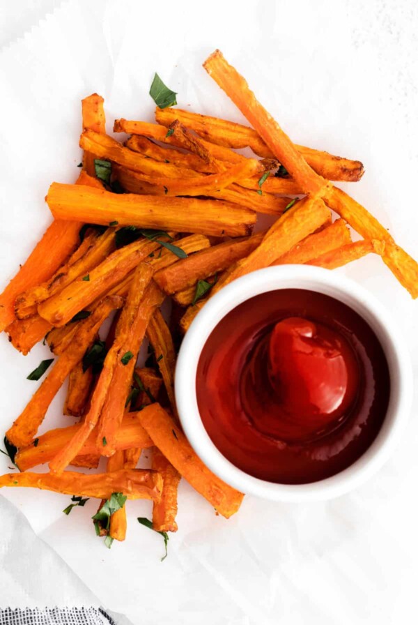 air fryer carrots sitting on a plate with a side of ketchup