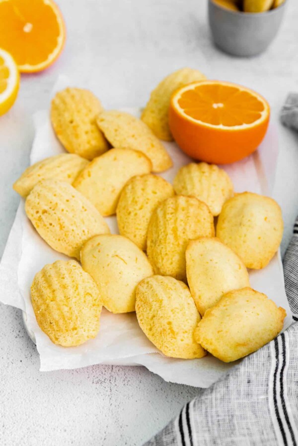 baked citrus madeleines sitting on a piece of parchment paper