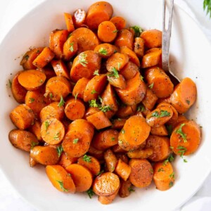 A bowl of sauteed carrots with parsley