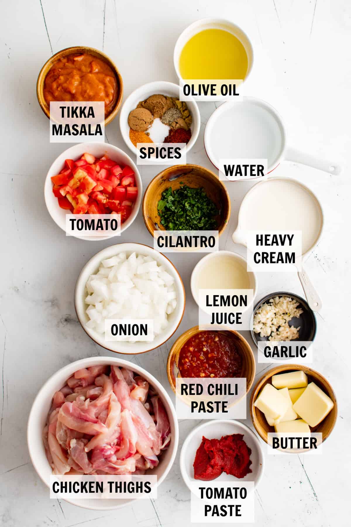 all of the ingredients for butter chicken on a white tabletop