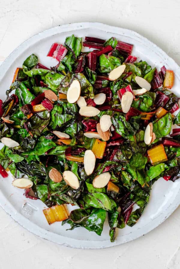 sauteed swiss chard on a plate with sliced almonds on top