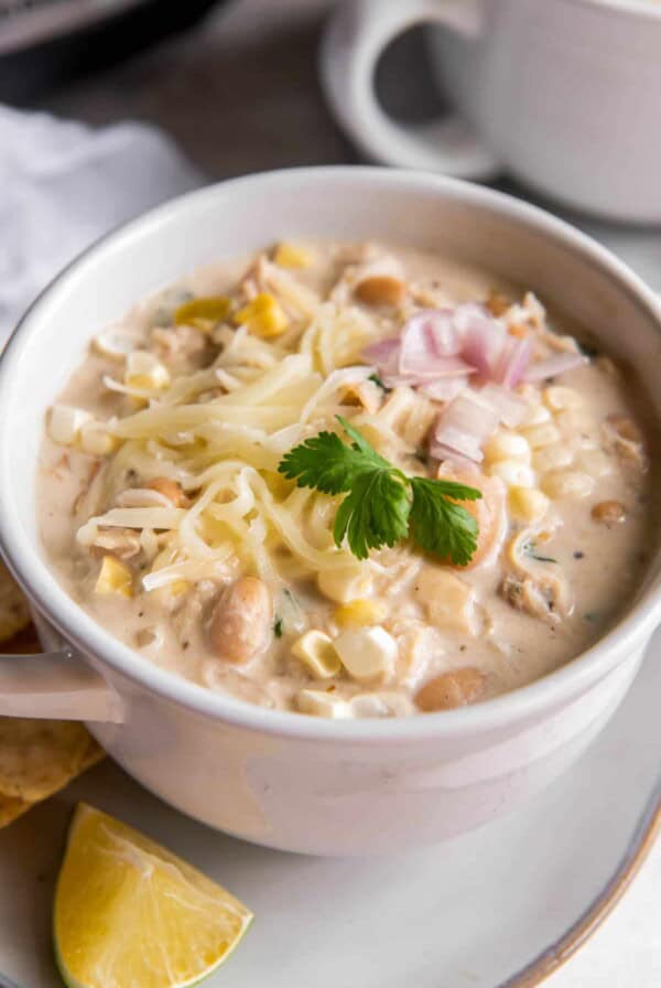 Crockpot Cream Cheese Chicken Chili in a bowl with cheese on top and chopped cilantro.