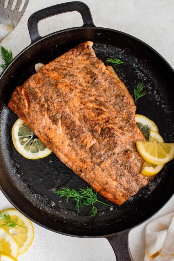 A cooked salmon filet in a cast iron ready for serving.