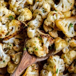 A spoon picking up sautéed cauliflower to serve.