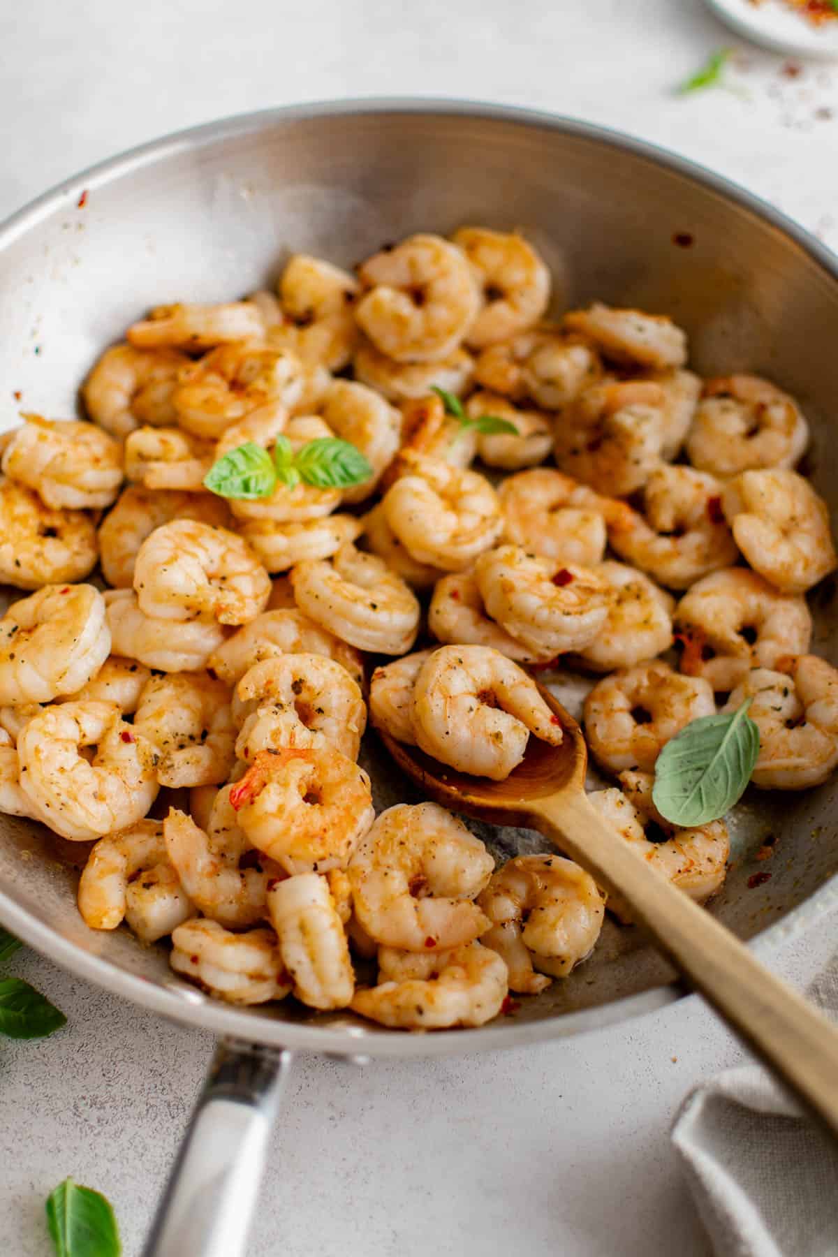 A skillet with pan seared shrimp in it ready to be served.