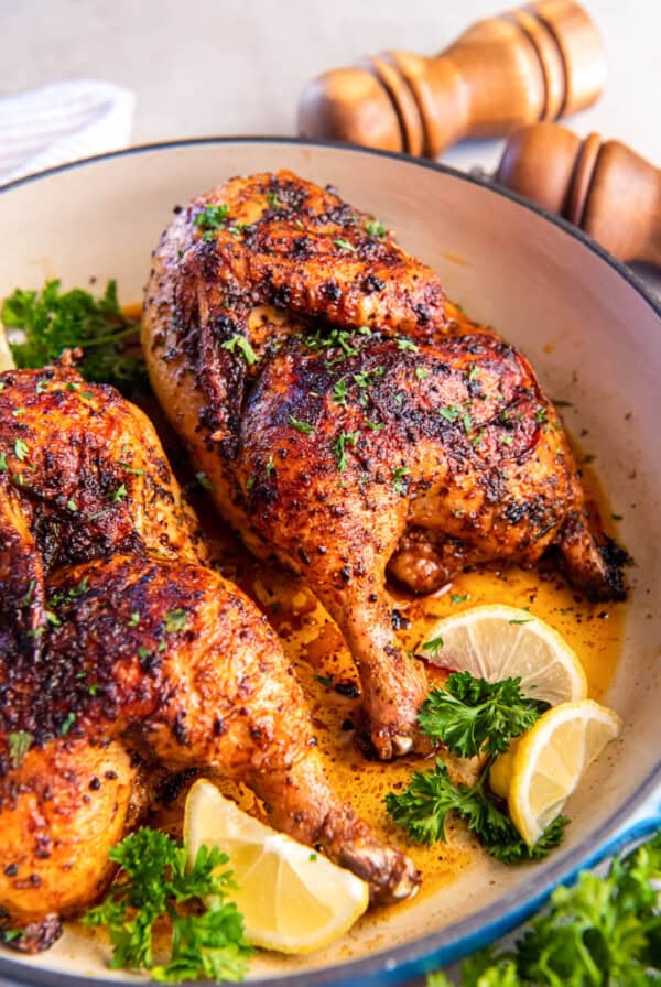 Roasted half chicken in a baking dish ready to be served.