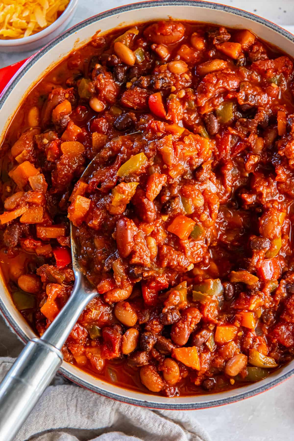 A large pot of three bean chili on a white tabletop.