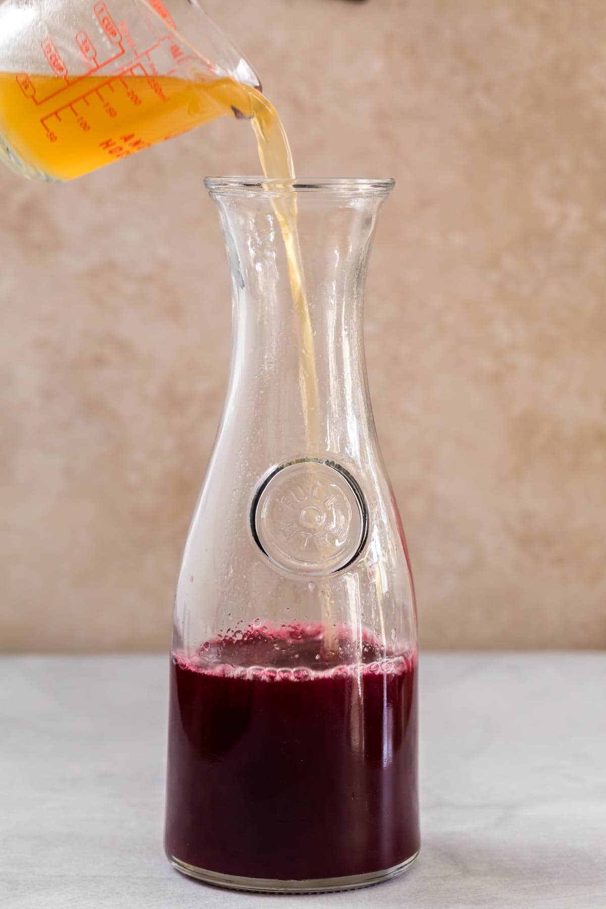 Pouring the honey water into the cranberry juice.